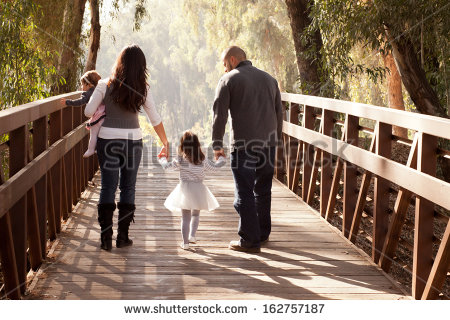 stock-photo-happy-family-walking-away-towards-a-forest-on-an-old-wooden-bridge-mother-father-two-daughters-162757187