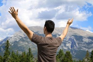 7483903-Man-standing-in-nature-with-arms-lifted-up-Stock-Photo-worship-christian-hope