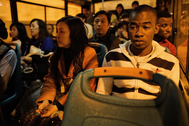 GUANGZHOU, CHINA - DECEMBER 17:  African trader Nelson sits on a bus taking him home December 17, 2008 in Guangzhou, China. In Guangzhou, the largest city in south China, 20.000 Africans are trying to make a life for themselves as traders in wholesale markets. Here, they hope to carve out their own piece of the Chinese economical miracle. The traders buy clothes and other cheap goods to be shipped and sold back home. Approximately 80% of the Africans in Guangzhou are Nigerians, others are from e.g. Ghana, Kenya and Cameroon.  (Photo by David Hogsholt/Edit by Getty Images)